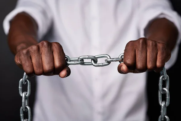 Be the strongest link in the chain of life. a man holding a metal chain against a black background