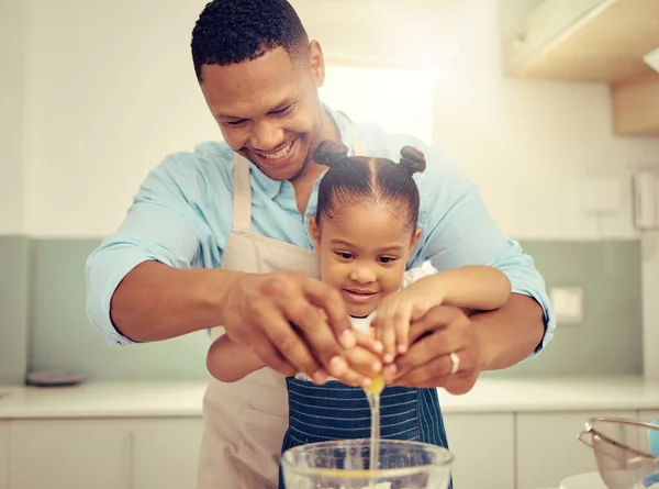 Happy black father and daughter baking in a kitchen, having fun being playful and bonding. Caring parent teaching child cooking and domestic skills, prepare a healthy, tasty snack or meal together.