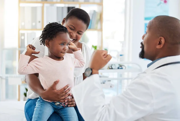 Pediatrician doctor with black family, baby and mother in clinic or hospital checkup appointment for growth wellness. Child in strong muscle flex for calcium with fun male medical pediatrics expert.