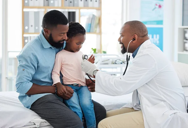 Black family, girl and pediatrician doctor with stethoscope, consulting healthcare worker or medical employee. Kids, happy father with smile or trust pediatrician in hospital insurance test for heart.