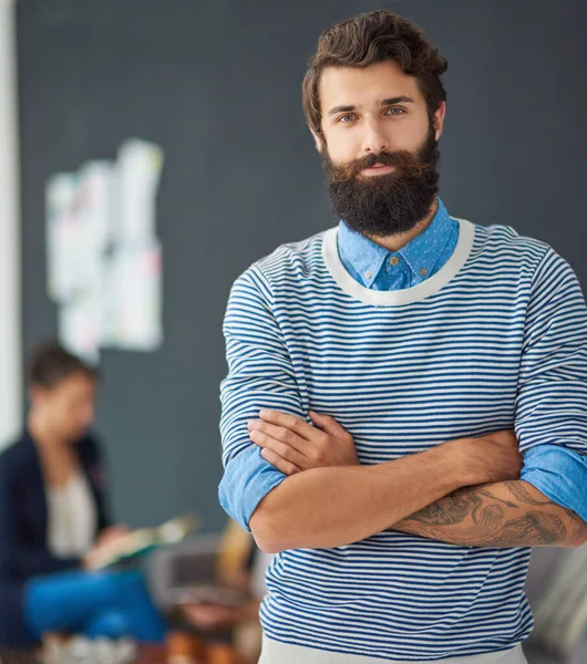 I have confidence in my teams ability to get the job done. Portrait of a handsome young businessman standing with his arms folded with his colleagues meeting in the background