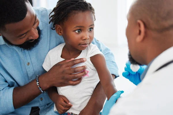 Father, child in consultation with pediatrician doctor for medical healthcare, insurance and trust. Black people, girl and men consulting appointment in hospital clinic for kid or toddler vaccination.
