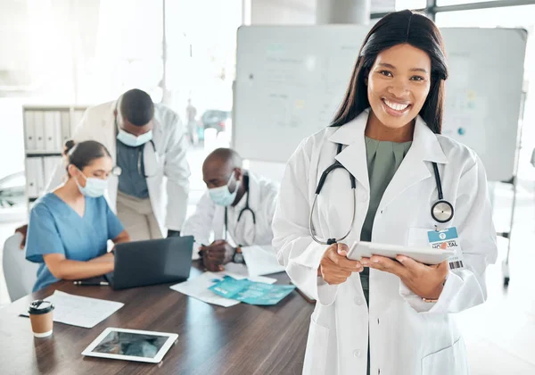 Portrait of happy doctor with digital tablet in a planning meeting with healthcare workers in an office. Medical expert research on laptop during teamwork, collaboration and support strategy online.