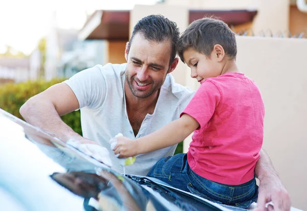 Daddys little helper. a handsome father and his son washing a car together