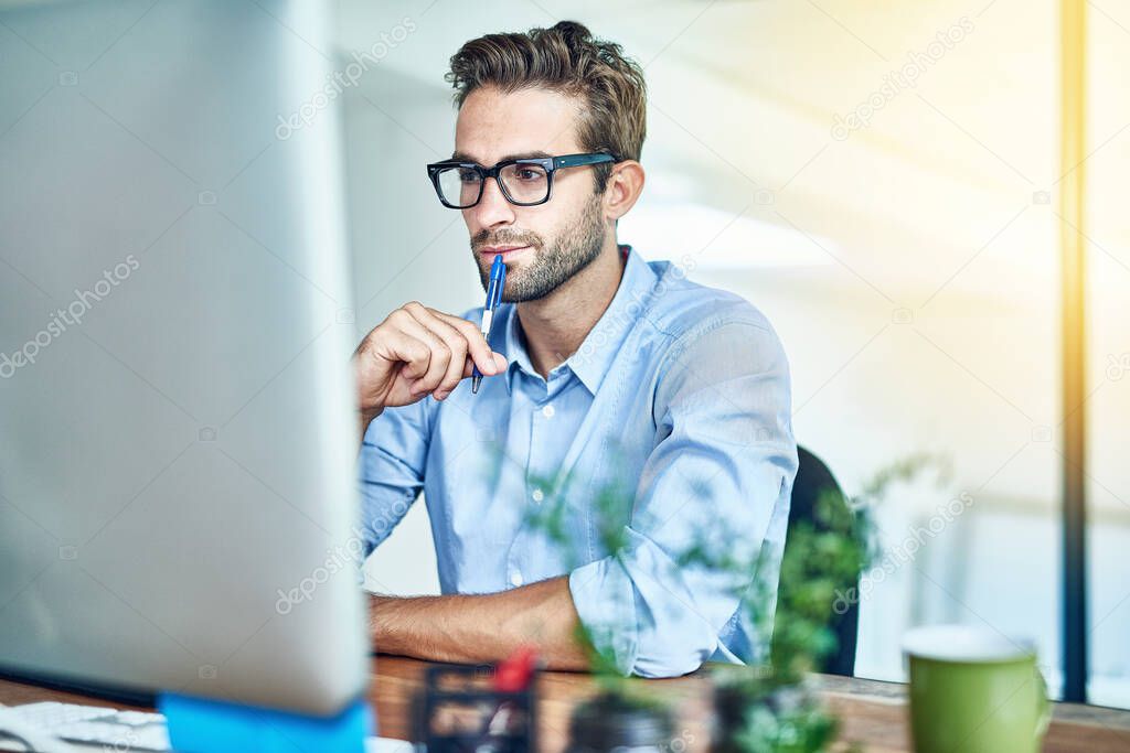 This looks interesting. a young businessman working on a computer in an office