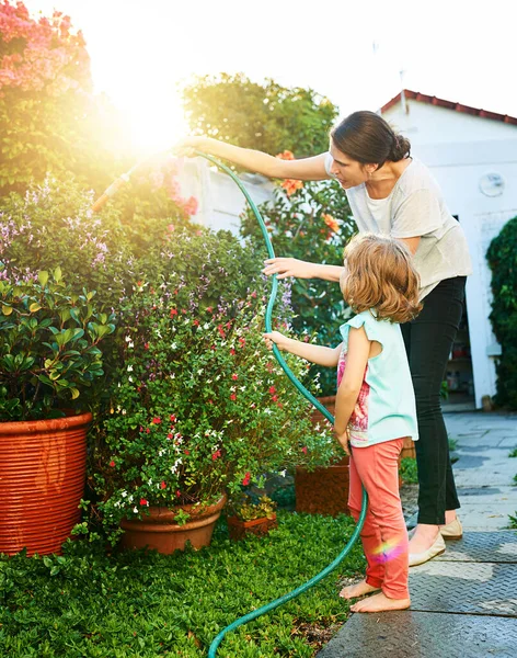 Taking care of the garden is her job now. a mother and daughter doing chores together at home