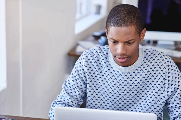 Hes always hard at work. a young designer working on his laptop