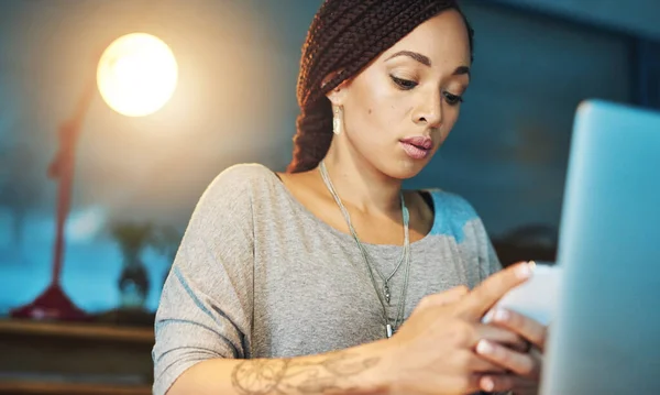 Making sure she stays on schedule. a young woman sending an sms while working late in her office