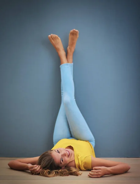 When life turns you upside down simply adjust your view. a young woman upside down against a grey wall