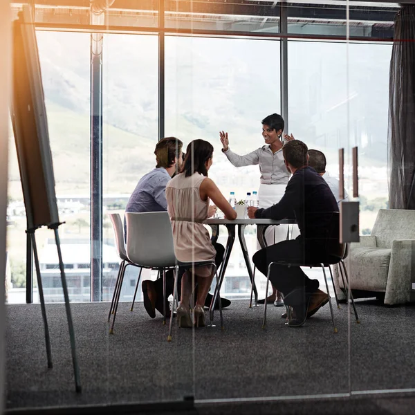 Passing on her experience in business. a businesswoman giving a presentation to a group of colleagues in a boardroom