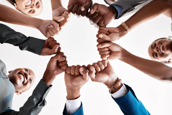 Hands, collaboration and motivation with a business team in a huddle with fists and a mindset of company vision. Mission, teamwork and goal with a group in a circle ready for growth and development.