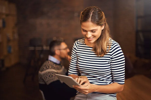 Making notes on her tablet. a young businesswoman sitting in the boardroom