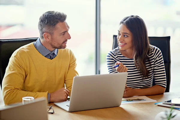 Successful people build each other up. coworkers working together on a laptop in an office