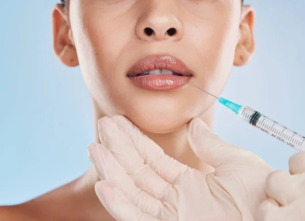 Plastic surgery, collagen and lip filler for facial beauty aesthetic and medical cosmetic surgery. Hands of face augmentation surgeon or doctor working on patient or client lips with injection needle.