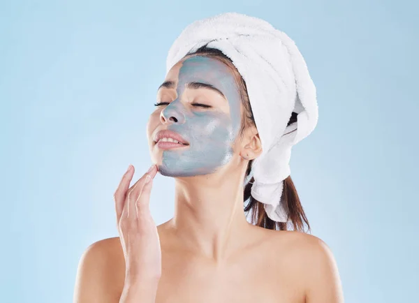 Charcoal face mask for skincare, cosmetic beauty for health skin and woman care for body against blue mockup studio background. Healthy, young and calm model doing self care with wellness product.