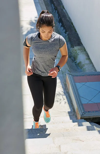 Taking the steps toward fitness. a fit young woman running up a flight of stairs