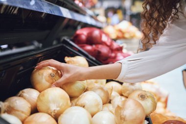 Vegetables, grocery shopping and health while a customer choose fresh onions in supermarket or greengrocer store. Close up hands of woman buying vegan food groceries before inflation at retail market. clipart