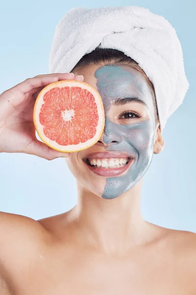 Skincare, face mask and grapefruit with a woman during her skin routine for clean and clear complexion. Young model with healthy fruit nutrition for face with natural ingredients and diet for health.