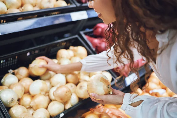 Supermarket, onion and customer shopping for healthy food, cooking and wellness product in grocery store. Happy, smile and black woman with nutrition vegetable choice on sale in retail shop for meal.