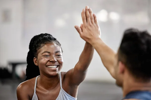High five, fitness team and gym success of friends in happy exercise workout together for health and wellness. Black woman with smile, excited and goal in teamwork celebration with her training coach.