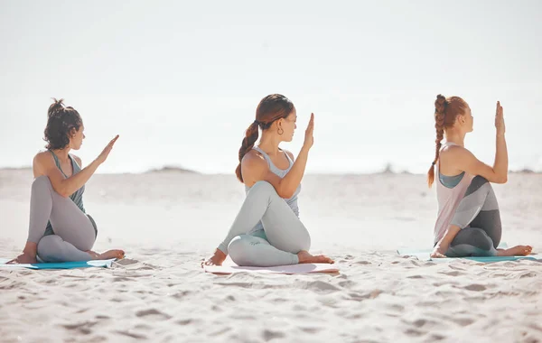 Zen, heath and yoga group meditation on a beach with women training and meditating together. Athletic friends exercise, practice posture and balance yoga pose with zen, peaceful energy in nature.