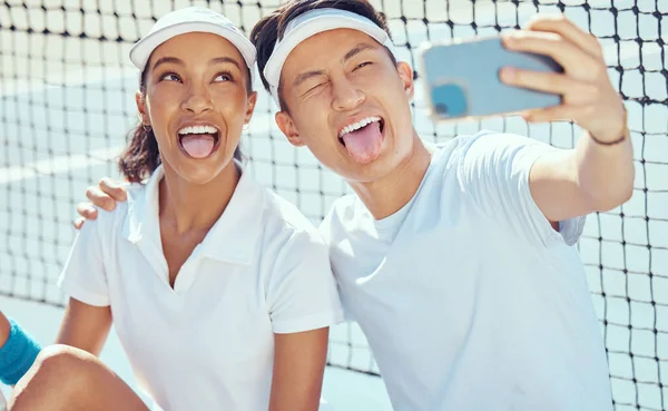 Tennis team taking funny selfie with phone, comic sports people being crazy training for sport competition on court and collaboration at fitness event. Happy, smile and relax athlete taking photo.