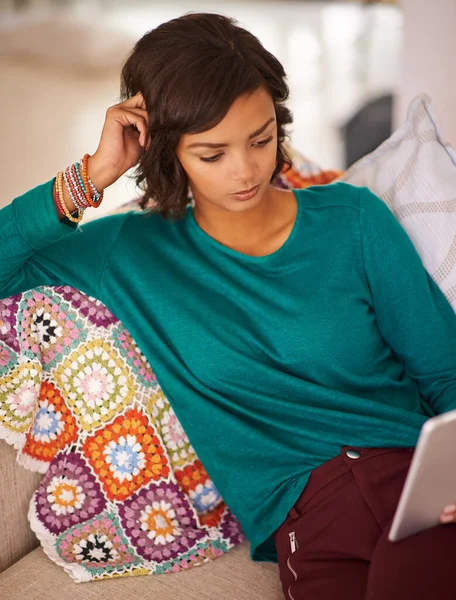 Indulging in the comforts of home. a young woman using a digital tablet on the sofa at home