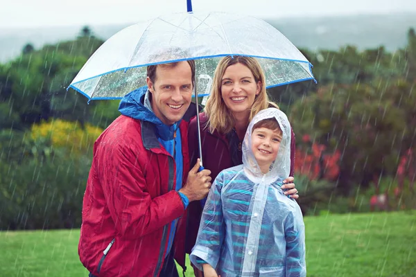 Rain or shine, we love the outdoors. Cropped portrait of a family of three standing outside in the rain
