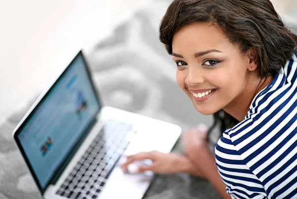 Everything I need for the weekend is on my laptop. a young woman using her laptop at home