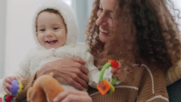 Счастливая Семья Мать Целуют Своего Ребенка Сидя Диване Гостиной Улыбайтесь — стоковое видео