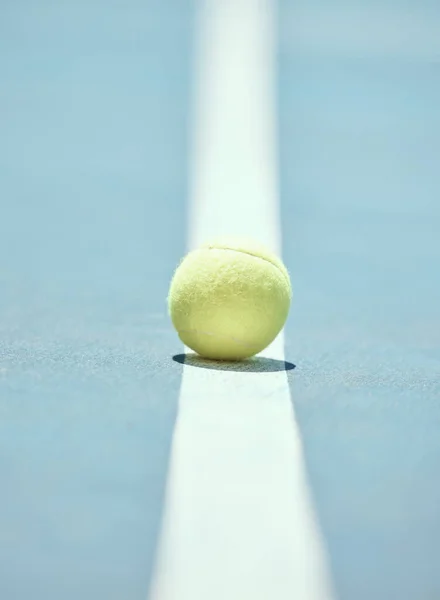 Tennis ball on the floor of a sports court during practice for a match in summer outdoors. Closeup of equipment for athlete team to train their strategy and skill for exercise and a game at stadium