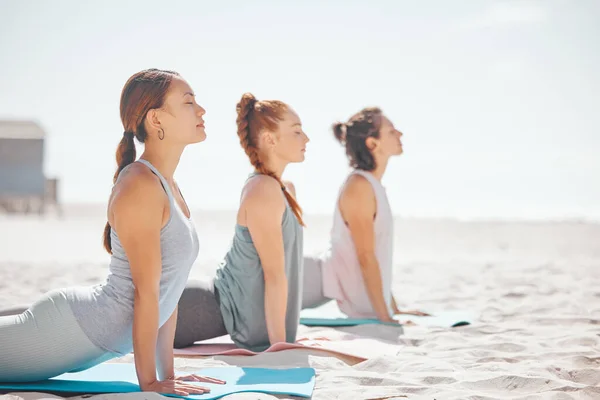 ビーチでヨガをしたり 自然の中で瞑想をリラックスしたり 海でのピラティスのクラス中に禅をしたり 夏の海でのウェルネスや精神的なワークアウトのためのコラボレーショントレーニング スポーツ海洋運動をする女性 — ストック写真