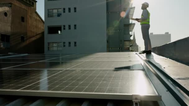 屋根の上に太陽電池パネルエンジニア 再生可能エネルギーと環境のための太陽光発電所の構築と持続可能性 持続可能な電力のための建設労働者と従業員計画戦略 — ストック動画