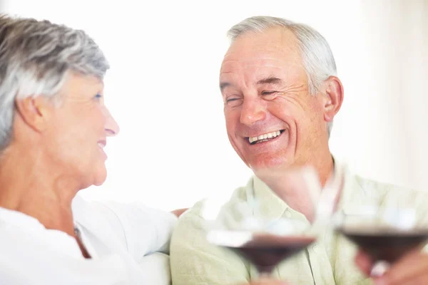 赤ワインで乾杯するカップル 笑顔成熟しました男と女Toastingとともに赤ワインとともにホーム — ストック写真