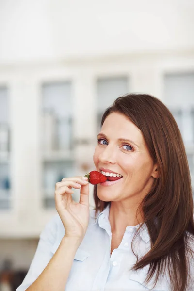 Bijtformaat Gelukzaligheid Een Aantrekkelijke Brunette Eten Een Aardbei Terwijl Staan — Stockfoto