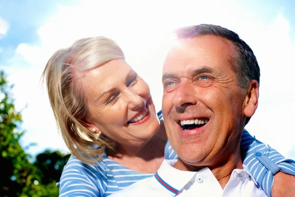 Cheerful man and woman spending time together against sky. Closeup portrait of a cheerful senior man and woman spending time together against sky
