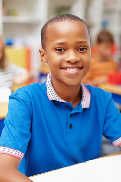Tomorrows leaders in training. Portrait of a confident young african-american student sitting proudly at his desk