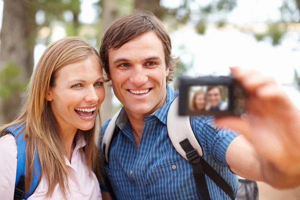 自画像夫妇与背包看着相机和微笑与男人点击照片 — 图库照片