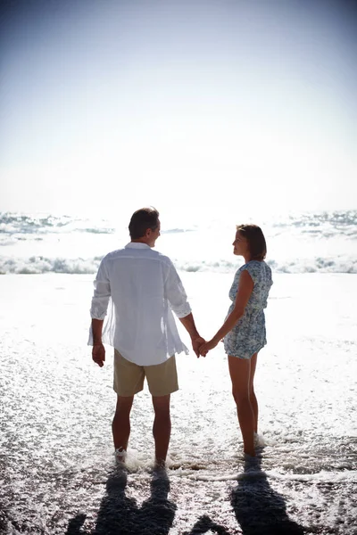 夏になるとロマンスが来る 幸せな成熟したカップルのレビュービーチで手をつないで歩く — ストック写真