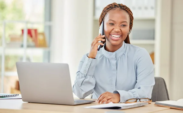 Black woman on laptop, business phone call and communication at office, work or workplace. Happy corporate female on smartphone, mobile or cellphone, conversation or talking while on computer