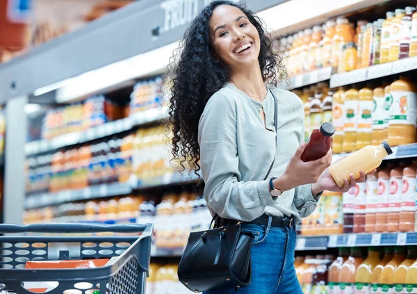 Woman with choice grocery shopping for juice in store, customer with healthy diet in supermarket and happy with retail sale on food at market. Portrait of girl with smile at shop for health drink.