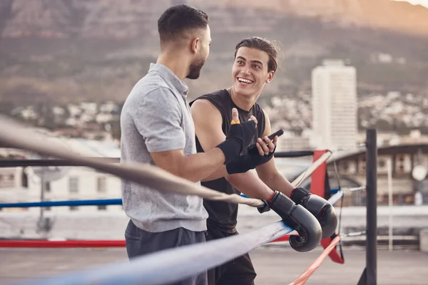 Boxing ring, strong men at outdoor gym talking fight strategy for fitness motivation, coaching goal with personal trainer. Professional boxer team people or wellness workout friends in extreme sports.