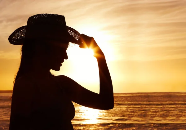 日没時に美しい海に対してわら帽子をかぶっている女性 夕日の美しい海に対してわらの帽子をかぶってフィット女性 — ストック写真