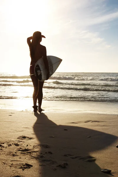 プロサーファー 海を見て若い女性 サーフボードを持って海を見ている若い女性の背面図 — ストック写真