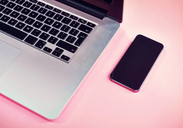 Bring your own device to the table. Studio shot of a laptop and smartphone on a pink background