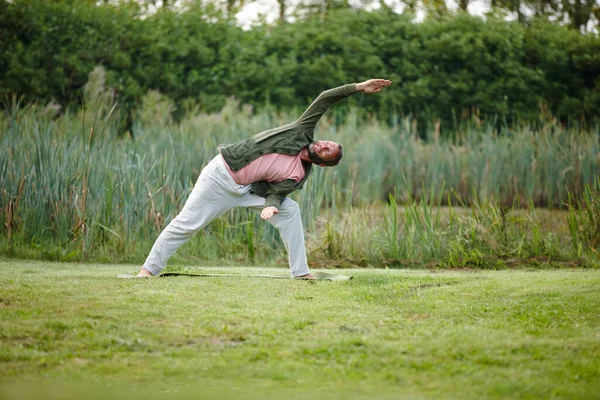 Less stress, more calm. a handsome mature man doing yoga at a park