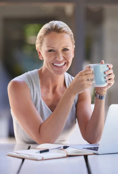 Coffee to keep my going. Cropped portrait of an attractive businesswoman working on her laptop