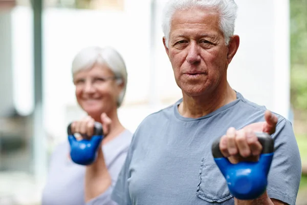 Strength training for seniors. a senior couple training with light weights outdoors