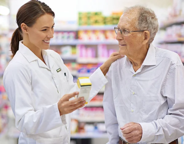 Finding the perfect remedy. a young pharmacist helping an elderly customer