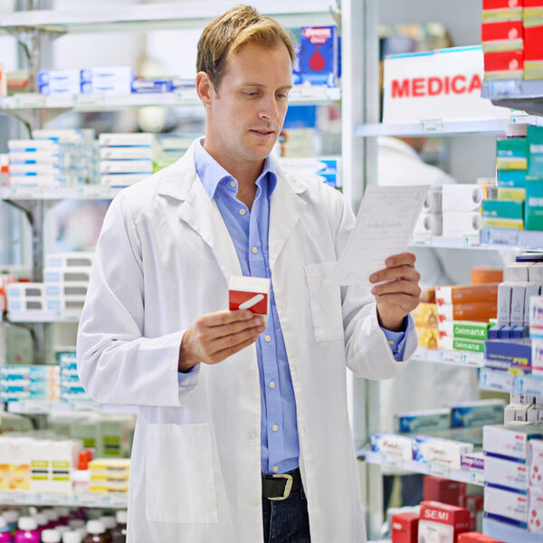 Ready to dispense your prescription. A pharmacist reading a prescription